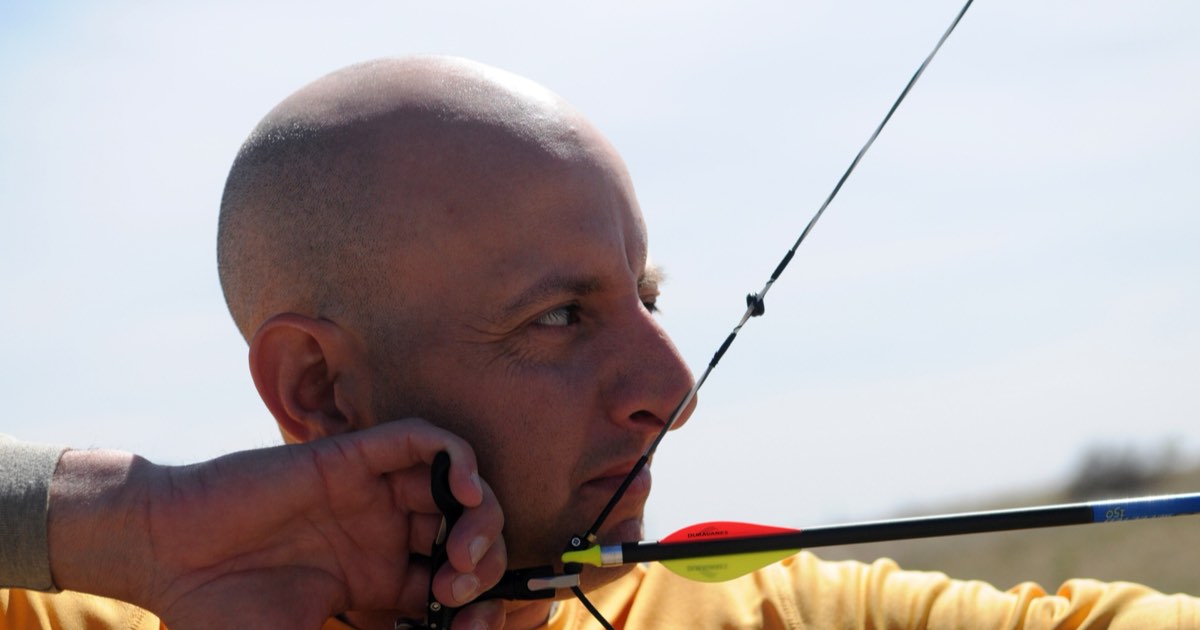 Close-up of an archer at anchor with the drawing hand under the jaw and the string at the face