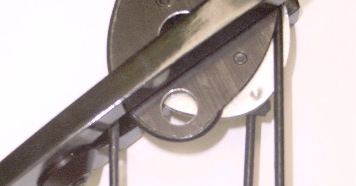 Close-up of a compound bow cam with the bowstring and cables wrapped around it