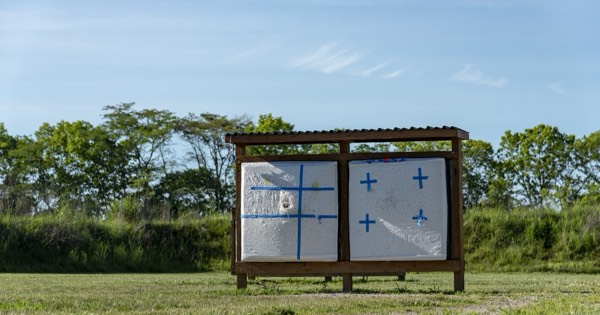 A layered foam block target in a wooden frame on an outdoor archery range