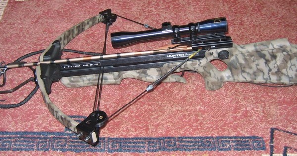 Hunting crossbow with a camouflage stock and a telescopic scope mounted on the rail