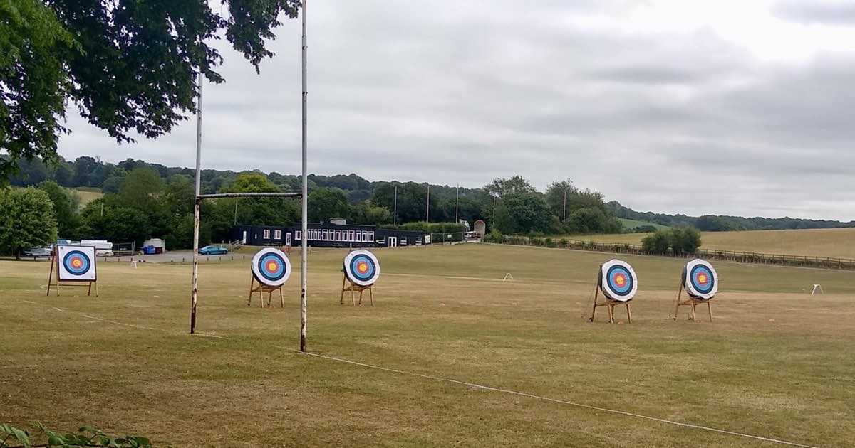 Several round target bosses on stands set out across a grass field