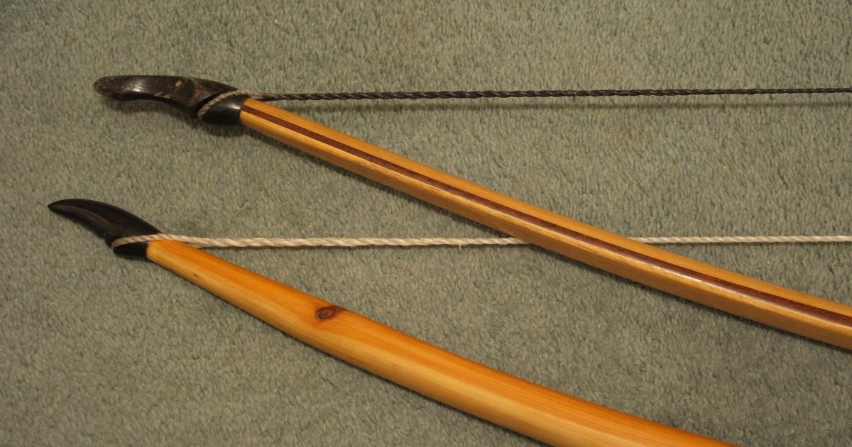 The tips of a self longbow and a composite longbow with their strings attached